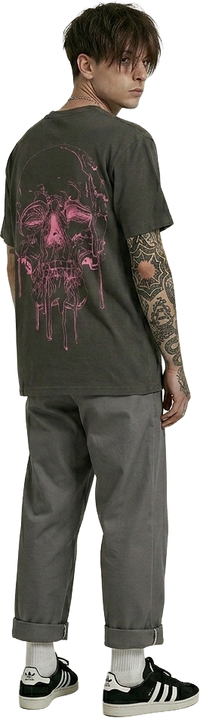 Man wearing a black t-shirt with a pink skull graphic design on the back, standing looking back..